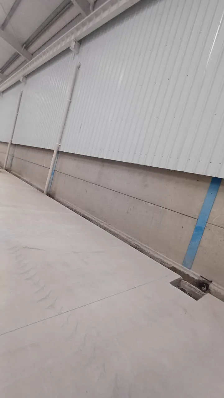 Placas de cerramiento instaladas en la base del muro de una nave industrial